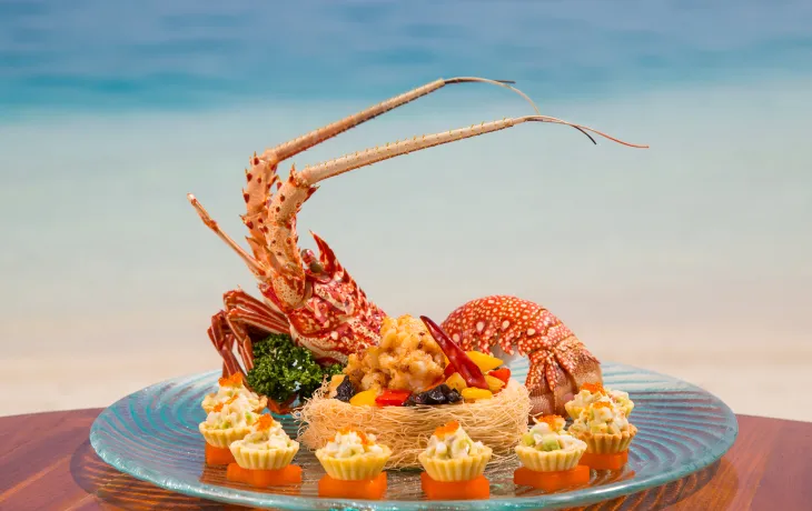 Discover the diversity of Maldivian cuisine beyond just seafood with this guide to 5 must-try dishes. From traditional fried yams and saagu bondibai pudding to fish-based sauce rihaakuru and live lobsters, there's something for everyone to enjoy in Maldives gastronomy. Learn about the blend of Indian, Sinhalese, and Arabic influences that make the Maldives' food unique, and find out where to get the best bites in the country.