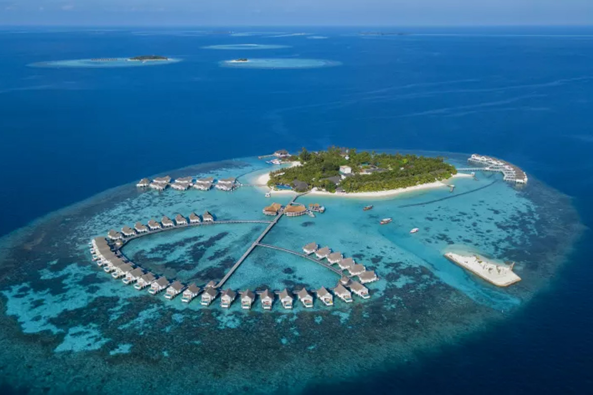 Which Maldives snorkelling resort offers easy access to coral reefs and diving excursions