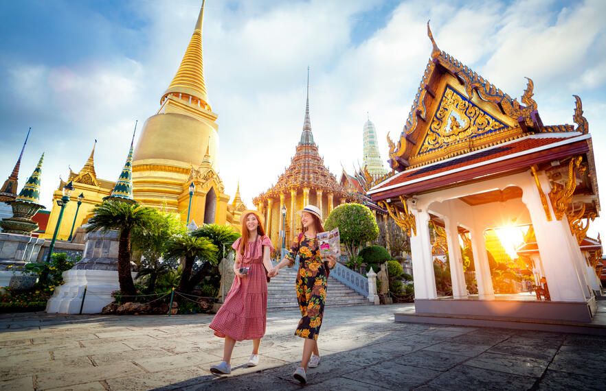 Tourists following Thai temple dress code and exploring