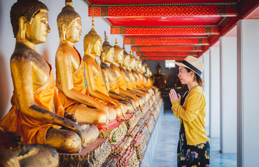 A woman praying at the Thai temple following the dress code 