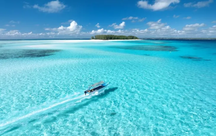 An aerial view of a boat zooming through the Maldivian sea 